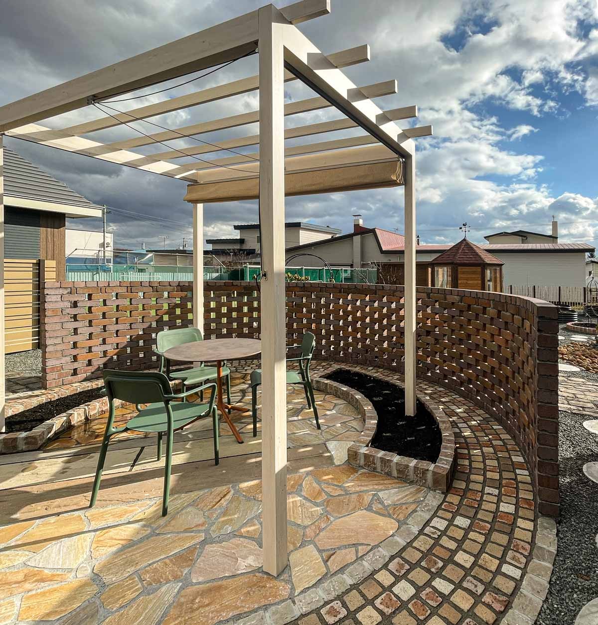 パーゴラと透かし煉瓦ウォールのバランス。上段と下段の高低差を違和感なく収めている。